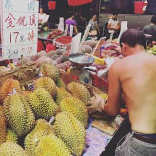 Local fruit market, the guy is selling durian.