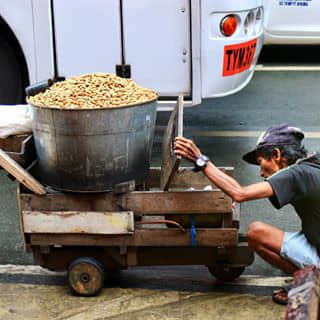 Guy selling peanuts in the street of downtown Manila.
